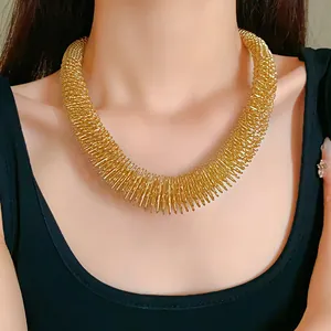Detailansicht eines klobigen goldenen Feder-Chokers an einem Modell