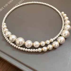 Primo piano della collana girocollo a doppio strato con perle irregolari e dorate