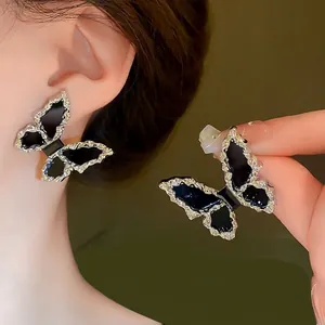 Elegant silver-tone butterfly stud earrings with black inlay and diamond-set edges