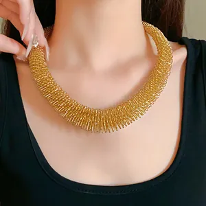 Nahaufnahme eines auffälligen goldfarbenen Feder-Halsreifs mit Metallic-Finish