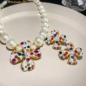 Detail of elegant pearl necklace and flower clip earrings with colorful rhinestones
