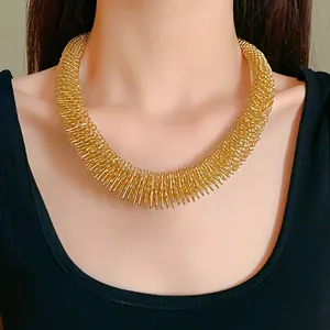 Nahaufnahme eines klobigen Gold-Federhalsbands mit einem einzigartigen Design.