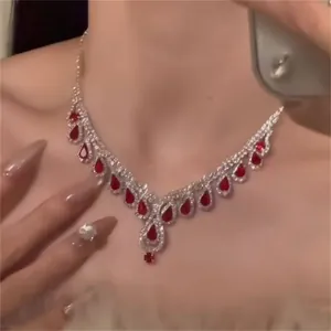 Close-up of red pear-shaped gemstone necklace with sparkling silver fringes on model