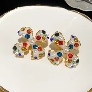Detailed macro shot of flower clip-on earrings with colorful rhinestones and pearls