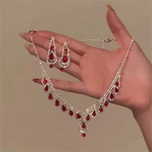 Detailed view of red teardrop stones and rhinestone accents on necklace and earrings