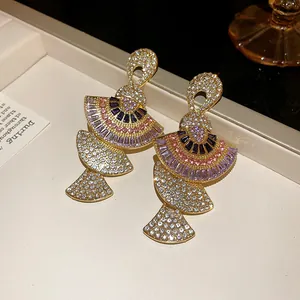 Macro view of vintage fan-shaped earrings featuring colorful zircon and gold plating