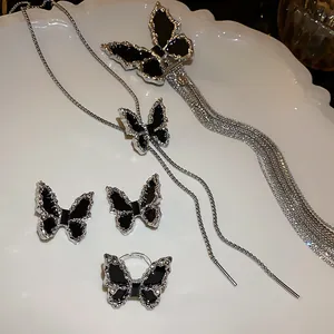 Elegant silver jewelry set with black butterfly motifs including necklace earrings and ring