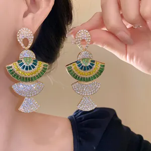 Detailed close-up of luxurious vintage style crystal fan-shaped dangle earrings worn on model
