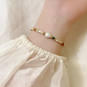 Macro shot of a French vintage beaded bracelet with a baroque pearl on a wrist.