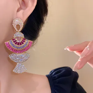 Close-up of vintage fan-shaped earrings with colorful rhinestones on an ear.