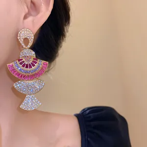 Close-up of vintage luxury fan-shaped dangling earrings with pink and purple rhinestones