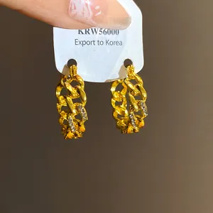 Detailed macro view of vintage gold chain hoop earrings with sparkling diamond accents