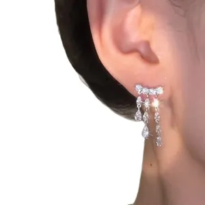 Elegant 18k gold plated zircon teardrop tassel earrings shown on a female model's ear
