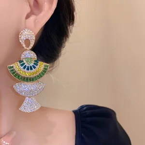 Detail shot of vintage fan-shaped statement earrings with green and yellow rhinestones