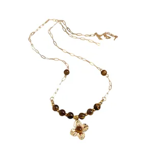 Vintage golden flower pendant necklace featuring natural tiger eye beads on a link chain