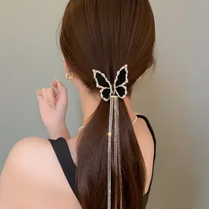 Elegant black butterfly hair clip with shimmering long rhinestone tassels worn by model