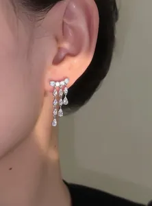 Close-up view of elegant 18k gold plated zircon teardrop tassel earrings on ear
