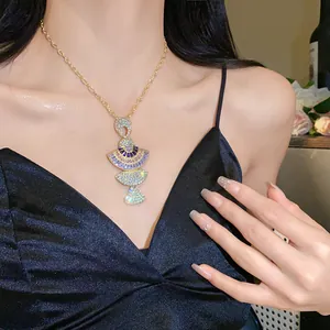 Detailed view of an elegant gold necklace with multi-colored fan-shaped crystal pendant