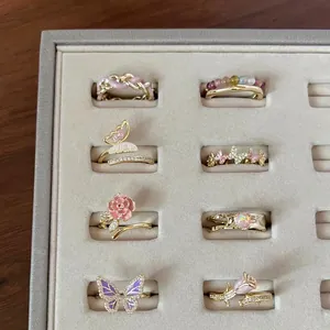 Elegante collezione di anelli con farfalle e rose in zirconi in un vassoio per gioielli