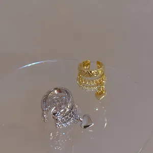 Macro view of the multi-layered zircon ear cuff featuring a polished heart charm