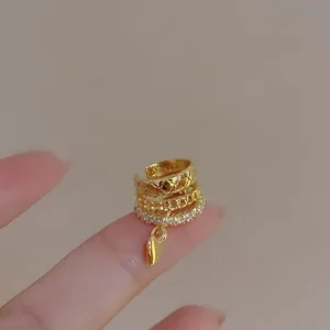 Detail view of a gold heart tassel ear cuff with zircon and quilted patterns