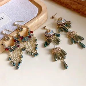 Nahaufnahme von Ethno-Ohrringen mit Quasten, bunten Kristallen und eleganten Perlen