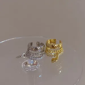 Detailed view of gold and silver heart tassel ear cuffs with sparkling zircon accents.