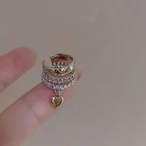 Detailed macro view of silver multi-layer heart ear cuff with sparkling zircon stones.