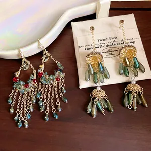 Detailansicht von Vintage-Quastenohrringen mit grünen Kristalltropfen und Kunstperlen