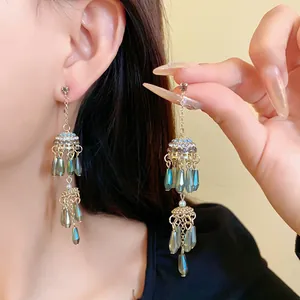Detailansicht der ethnischen Quastenohrringe mit blauen Perlen und Strass