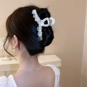 Macro view showing the elegant iridescent shell texture hair claw clip on a bun