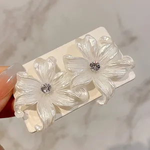 Elegantes pendientes de flores nacaradas con circonitas centrales brillantes para mujer