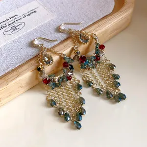 Detailaufnahme von böhmischen Quastenohrringen mit bunten Kristallen und Goldketten