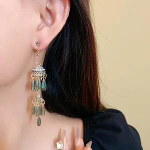 Ethno-Ohrhänger in Goldoptik mit blauen Tropfenperlen und glitzernden Strasssteinen