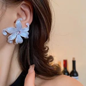 Elegante primer plano de pendientes de flores de resina blanca con centro de circón