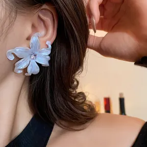 Detalle de un pendiente de lirio blanco con circón usado por una modelo asiática.
