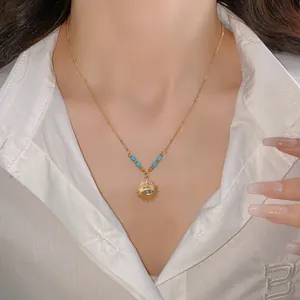Detailed close-up of a vintage sun flower pendant necklace with turquoise beads on a model.