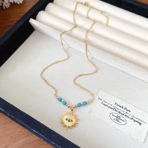 Detailed macro shot of vintage gold sunburst pendant necklace with turquoise bead accents