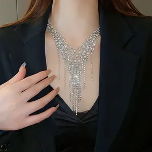 Detailed close-up of an elegant sparkling rhinestone tassel necklace worn with a black blazer