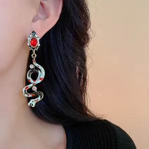 Close-up detail of a vintage palace style snake earring with enamel and red rhinestone