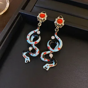Detailed macro view of vintage court style snake earrings featuring blue enamel and rhinestones