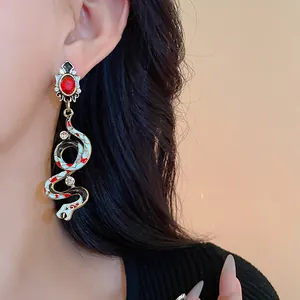 Detailed view of vintage snake drop earring with red gem and enamel detailing