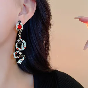 Detailed macro view of vintage snake earrings with red gemstone and colorful enamel