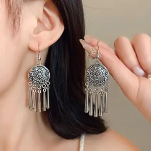 Vintage ethnic style silver tassel earrings with engraved round plates shown on model