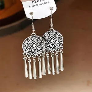 Ethnic style silver circular earrings with hanging vertical tassels on a display card