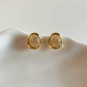Elegant detail of 18k gold plated circular clip-on earrings with fine zircon mesh inlay