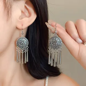 Detailed shot of retro silver ethnic earrings featuring round patterns and long tassels