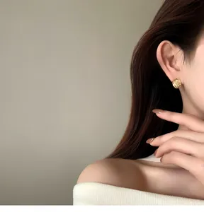 Detail view of elegant 18k gold plated round zircon ear clips worn by a female model