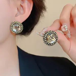 Detailed view of vintage gold round flower stud earrings featuring sparkling clear crystals