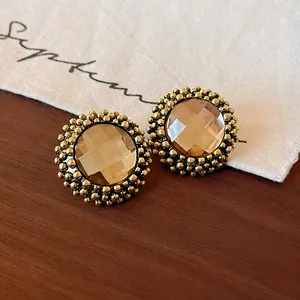 Vintage golden round stud earrings with faceted champagne stones and floral borders